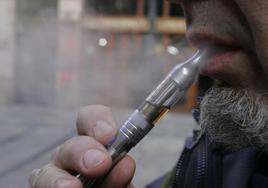 Un hombre fuma con un cigarrillo eléctrico.