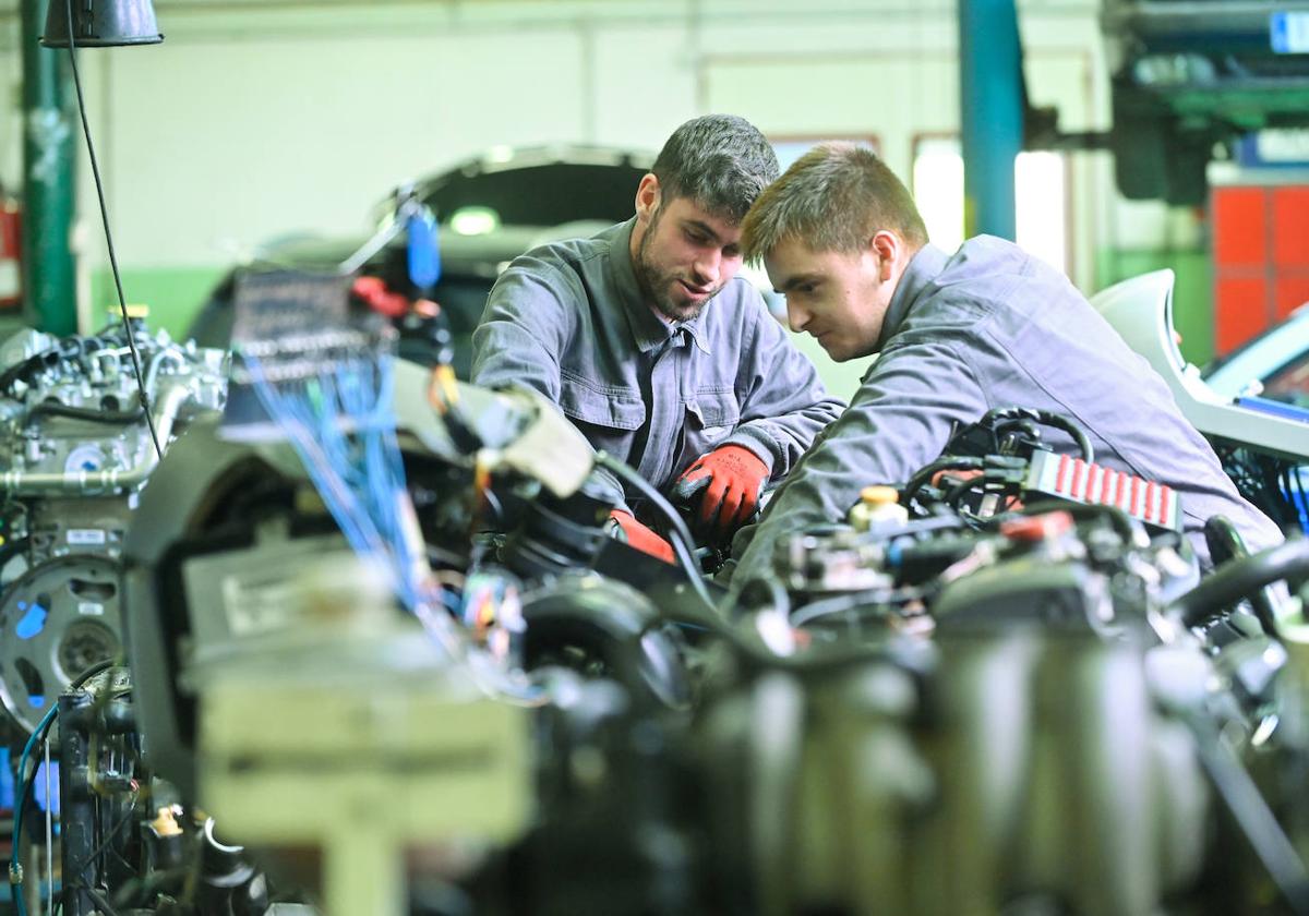 Dos alumnos trabajan con un motor en el Grado Superior de Automoción del centro Juan de Herrera.