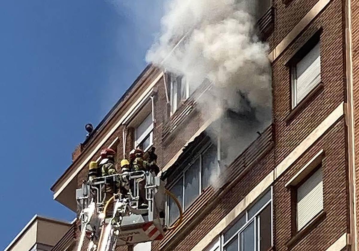Los Bomberos se disponen a entrar en la vivienda con una escala.