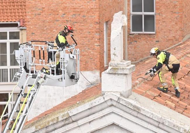 Los Bomberos sanean la cubierta de la capilla de Las Esclavas tras la caída del rayo que destrozó la cruz.