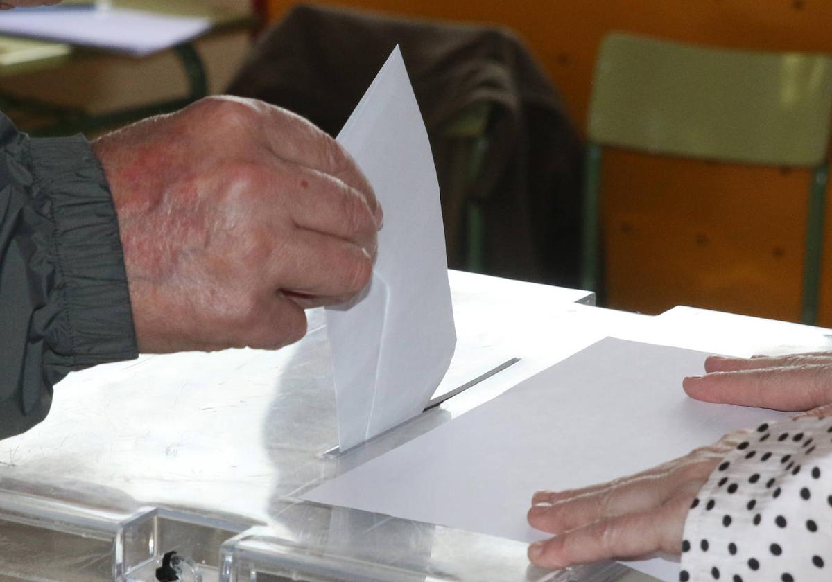 Un hombre introduce la papeleta en una urna en la votación de las elecciones municipales del 28 de mayo.