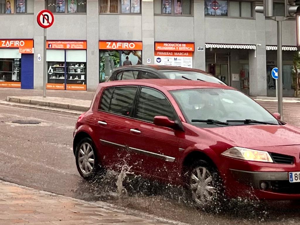 Un vehículo levanta el agua de un charco de Parquesol.