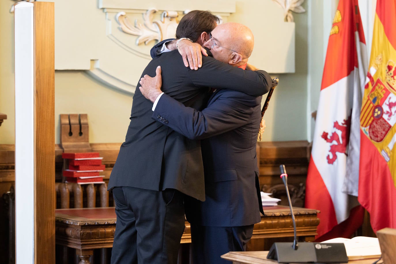 Abrazo entre el alcalde saliente y su sucesor en el cargo.