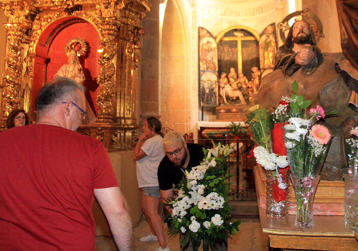 Colocación de flores en el paso de La Oración en el Huerto durante la jornada cofrade de este domingo.