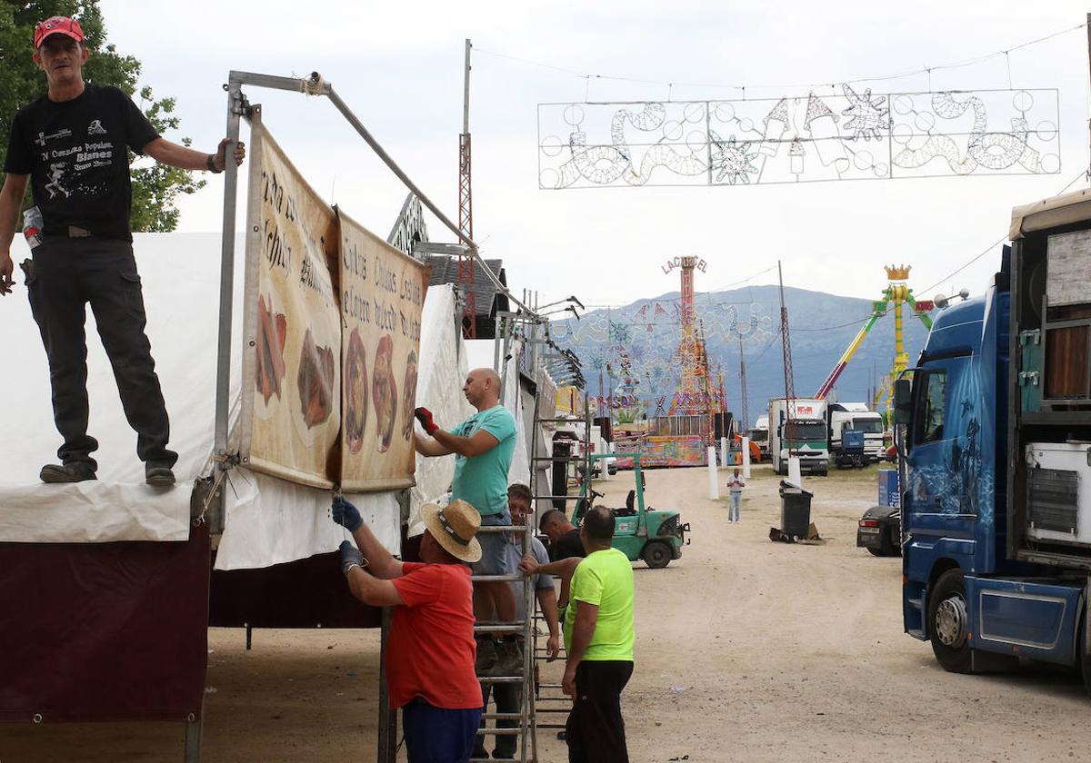 Algunos feriantes durante las tareas de montaje de un puesto hostelero en el recinto de La Albuera.