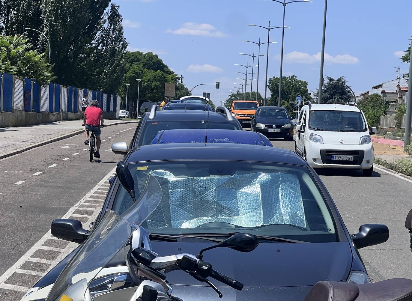 Caril bici de la avenida de Gijón junto al colegio Cristo Rey. Cochea aparcados y, a la derecha, carril único para vehículos.