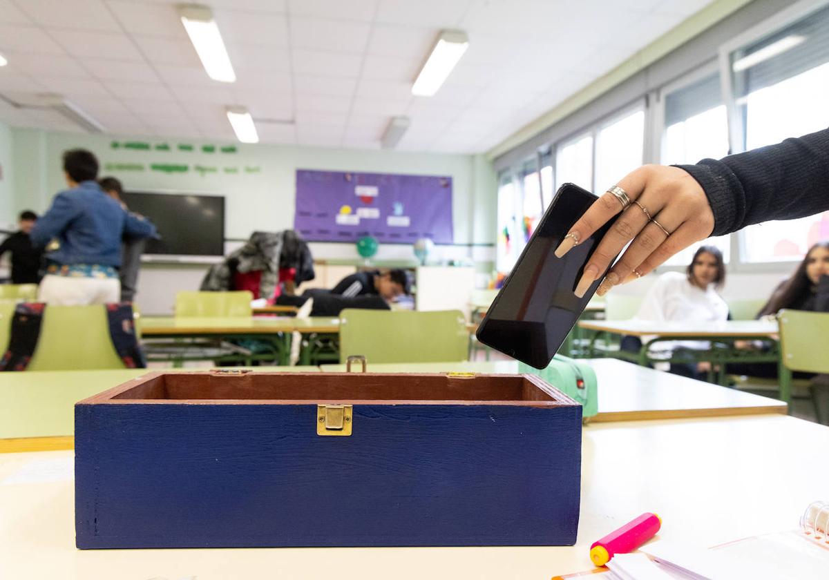 Alumnos del instituto Galileo dejan su móvil en una caja al entrar al aula.