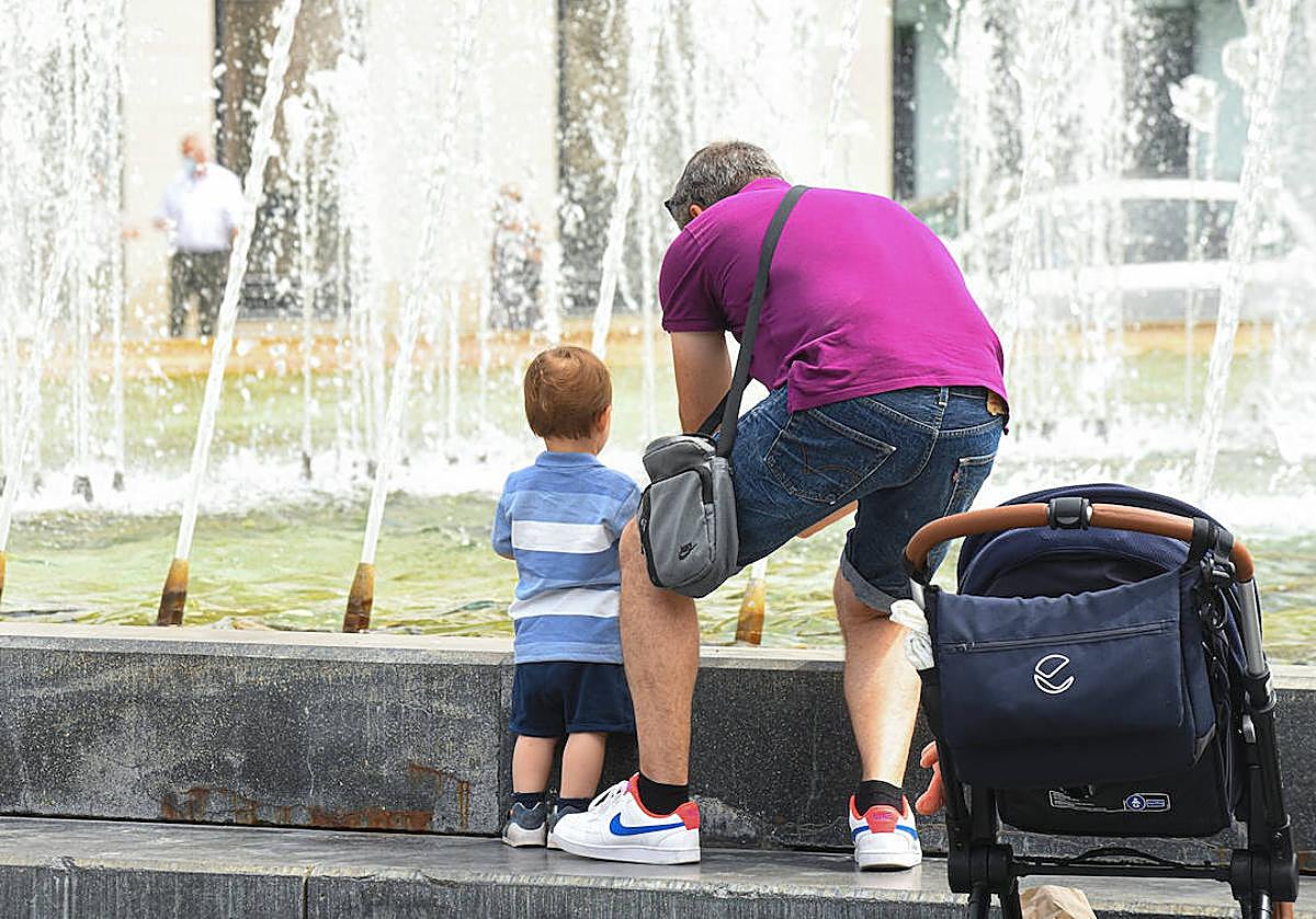 Un hombre se refresca junto a su hijo en la fuente de la Plaza de Zorrilla de Valladolid, en una imagen de archivo.