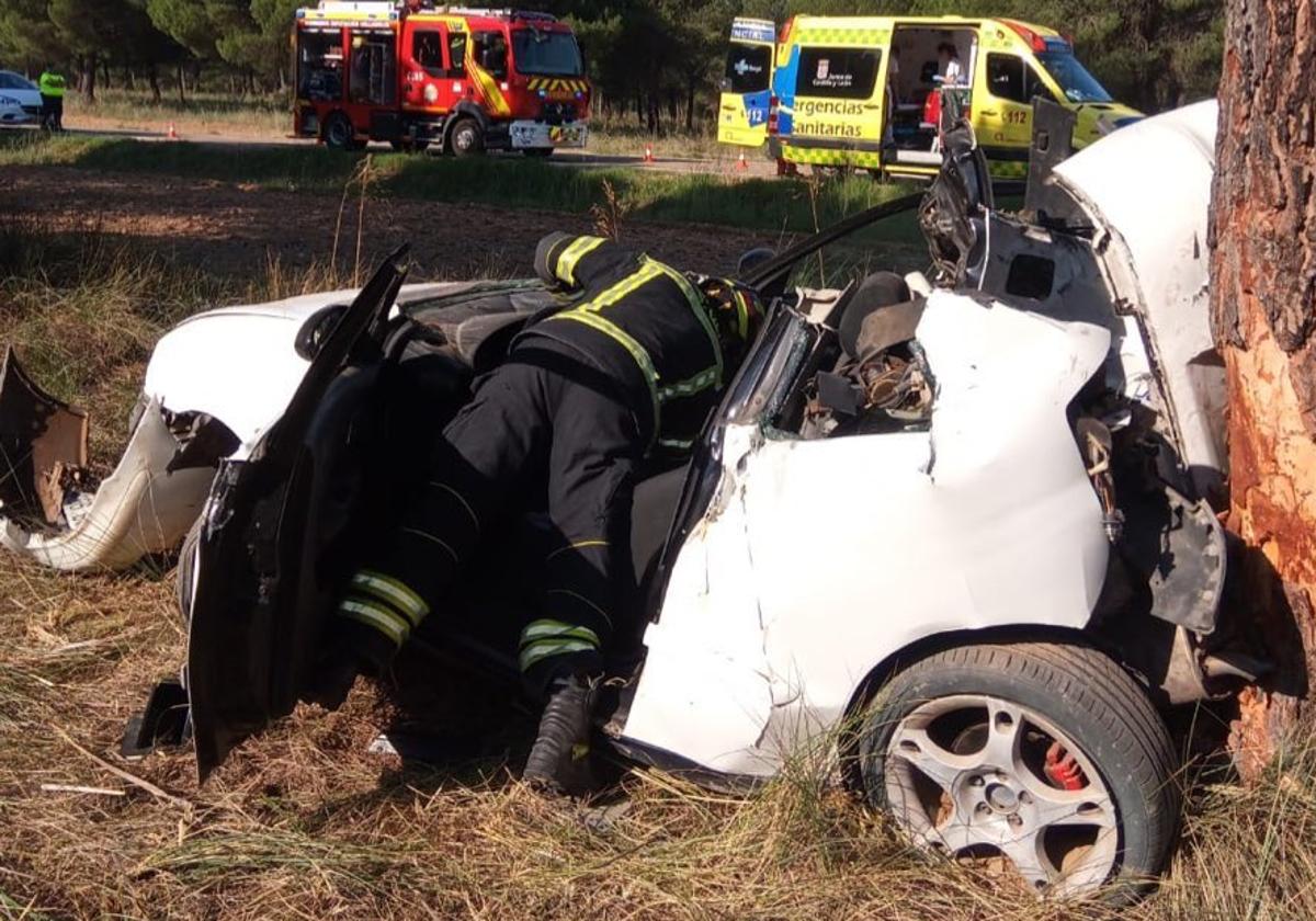 Los bomberos trabajan en el vehículo accidentado.