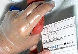 Trabajador sanitario realiza la prueba del talón a un bebé en un hospital.