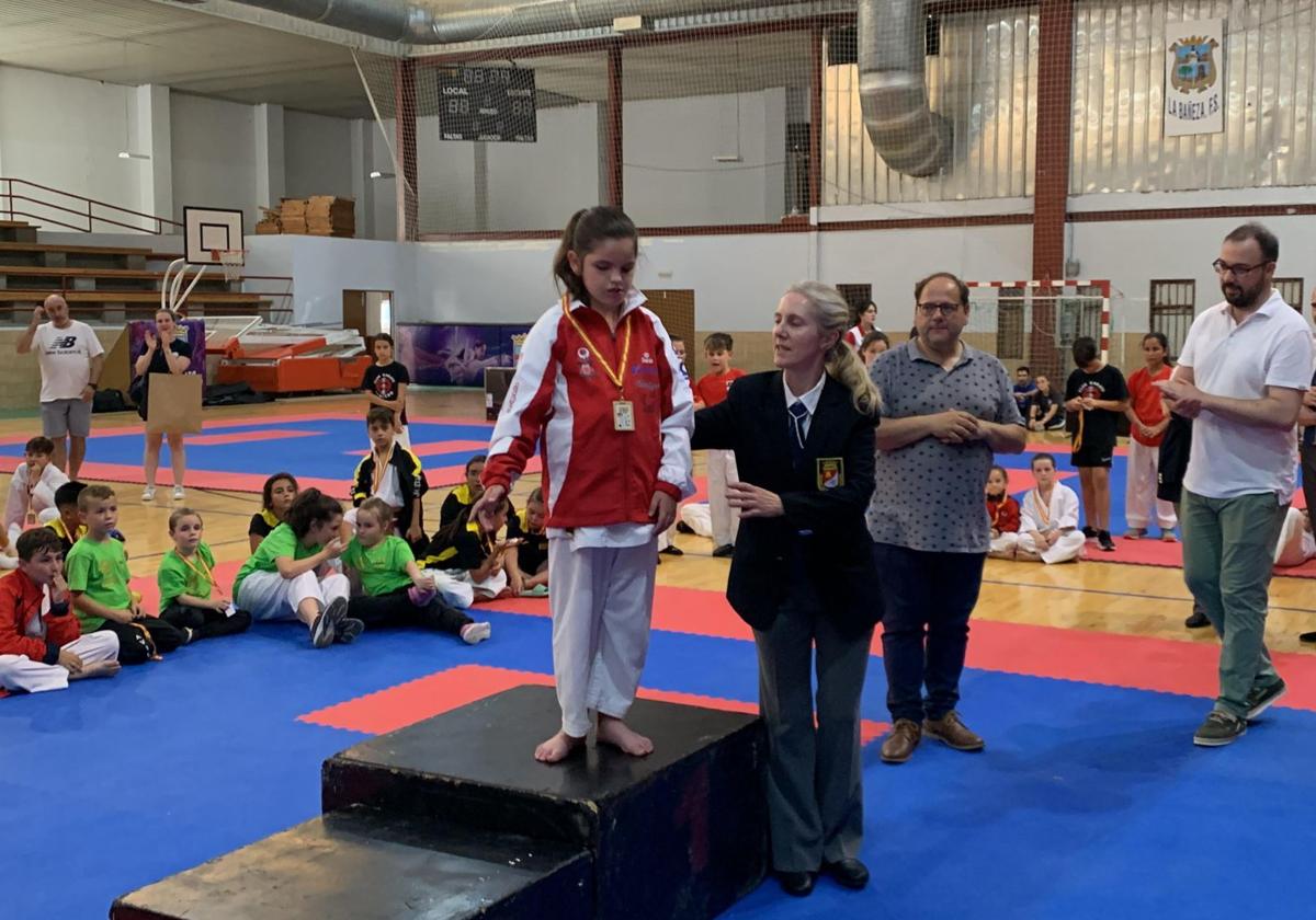 Lucía Gómez guiada para bajar del podio tras recibir la medalla de campeona de Castilla y León de Edades.