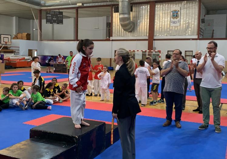 Imagen principal - 1. Lucía Gómez saluda en el podio antes de recibir la medalla de campeona de Castilla y León. 2. Yolanda García y Lucía Gómez. 3. Lucía posa con su medalla de oro en el Campeonato que se disputó en La Bañeza.