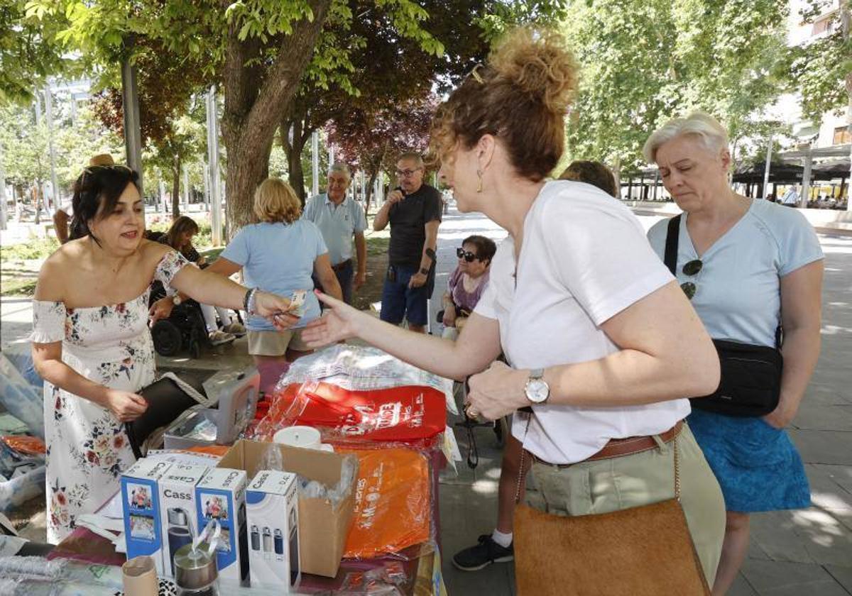 Una mujer compra artículos en el puesto de la asociación de esclerosis.