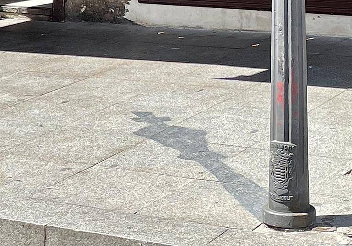 Falsa sombra en forma de pieza del ajedrez en un bolardo