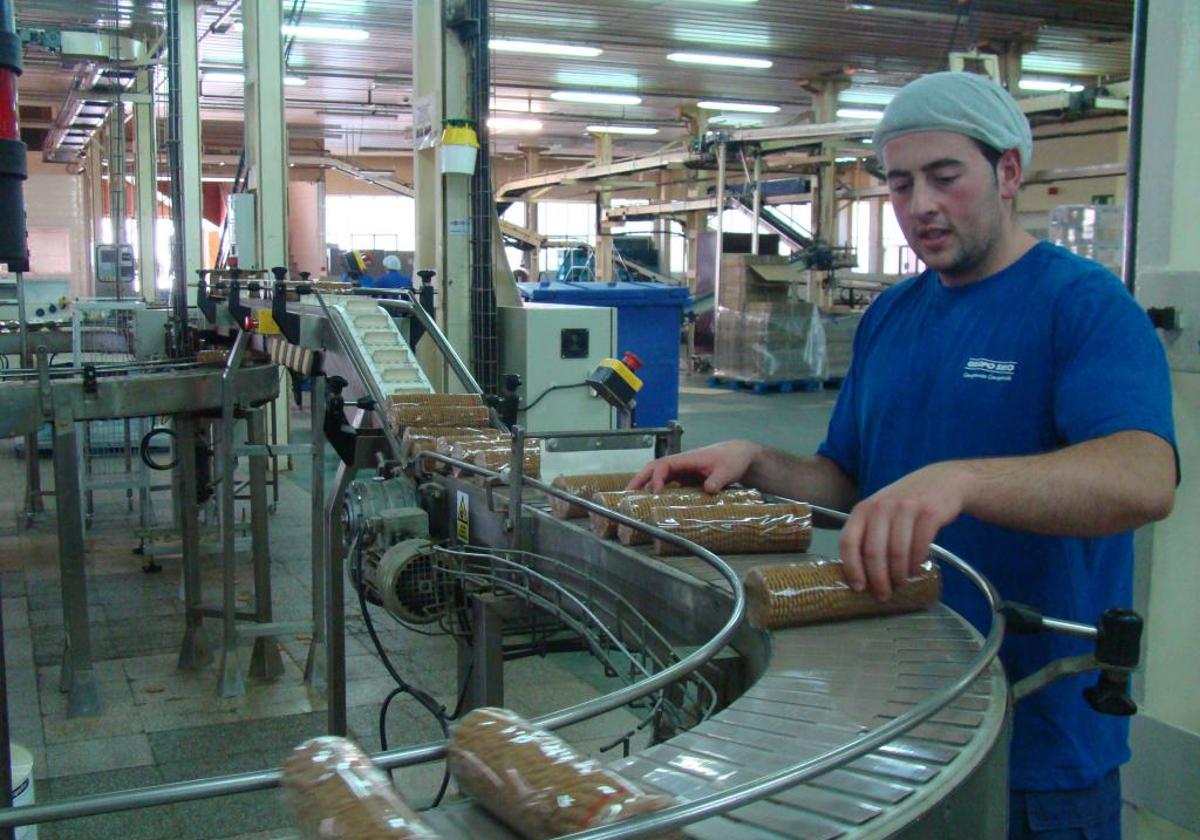 Un trabajador supervisa el empaquetado de galletas.