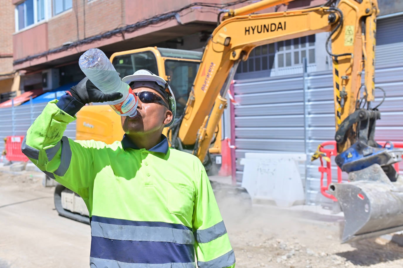 Un albañil se hidrata con agua ante el intenso calor