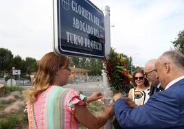 El decano coloca un ramo de flores junto a la cartela de la glorieta del Abogado del Turno de Oficio.