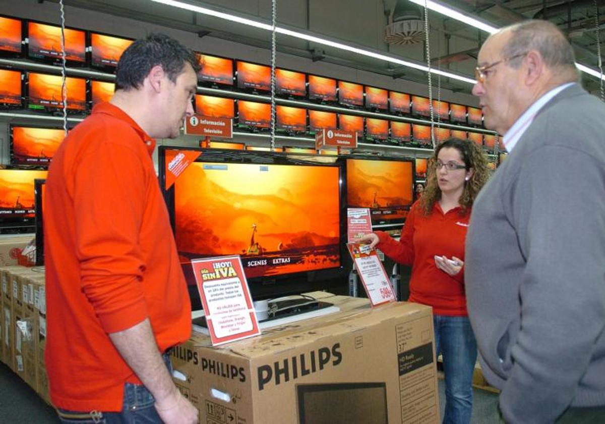 Un cliente se informa sobre las opciones de compra de un televisor en una tienda especializada.