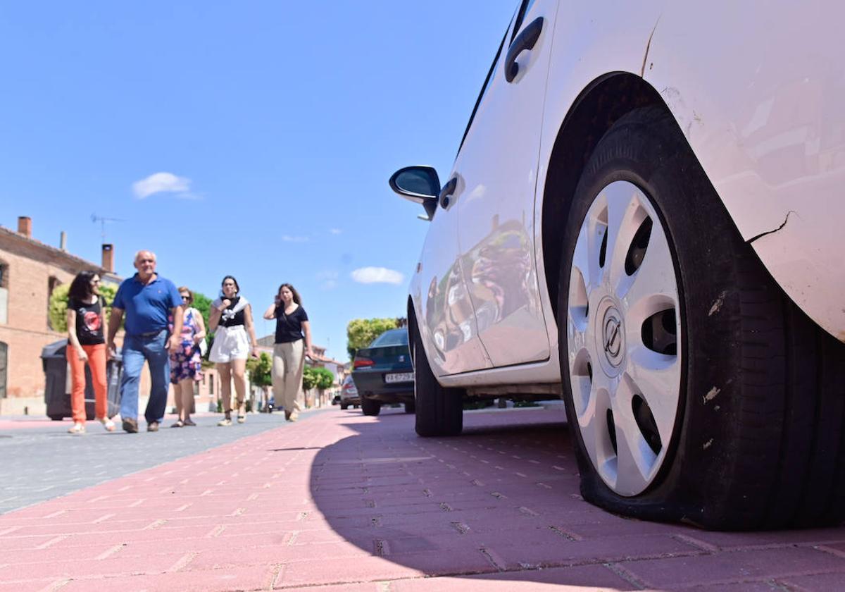 Varios vecinos de Alaejos caminan por delante de uno de los coches afectados por los actos vandálicos.