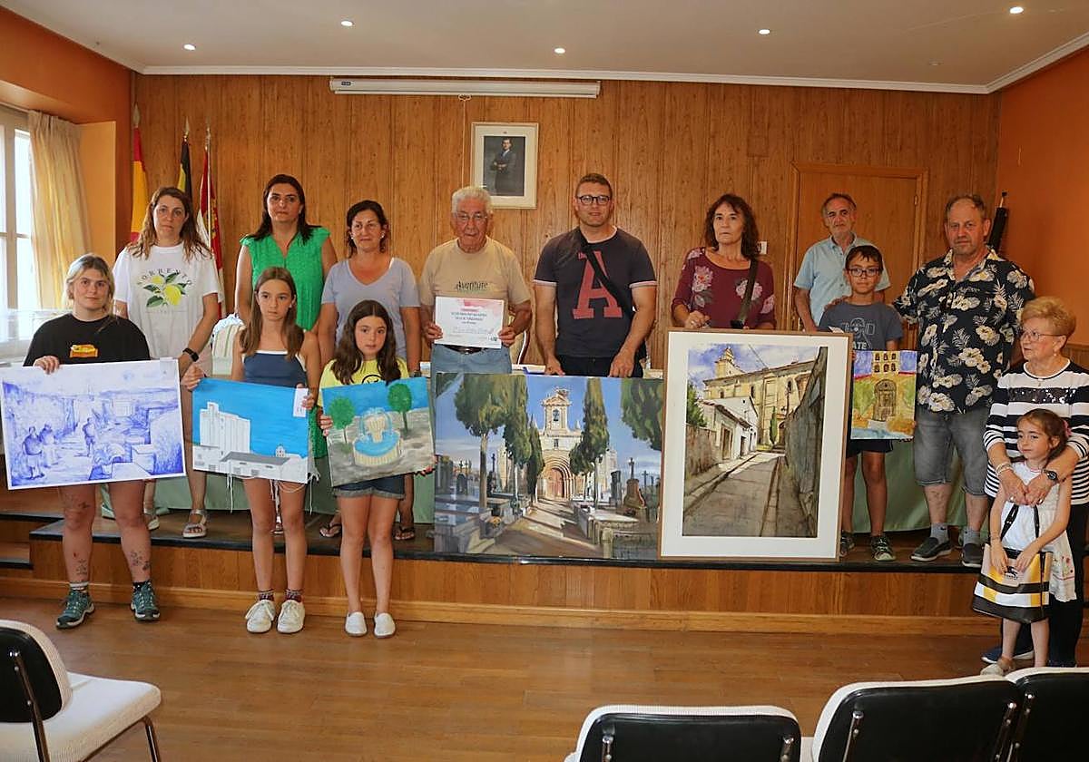 Los ganadores de los premios posan con sus cuadros.