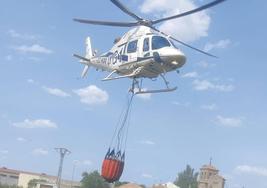 Un helicóptero lleva agua para desparramarla sobre el incendio en la zona de Ochando y Balisa.