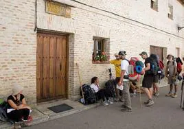 Un grupo de peregrinos espera para entrar en un albergue de Carrión de los Condes.