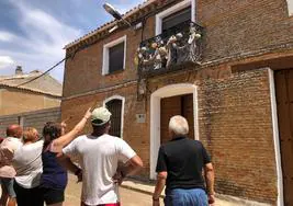 Los vecinos contemplan un balcón engalanado.