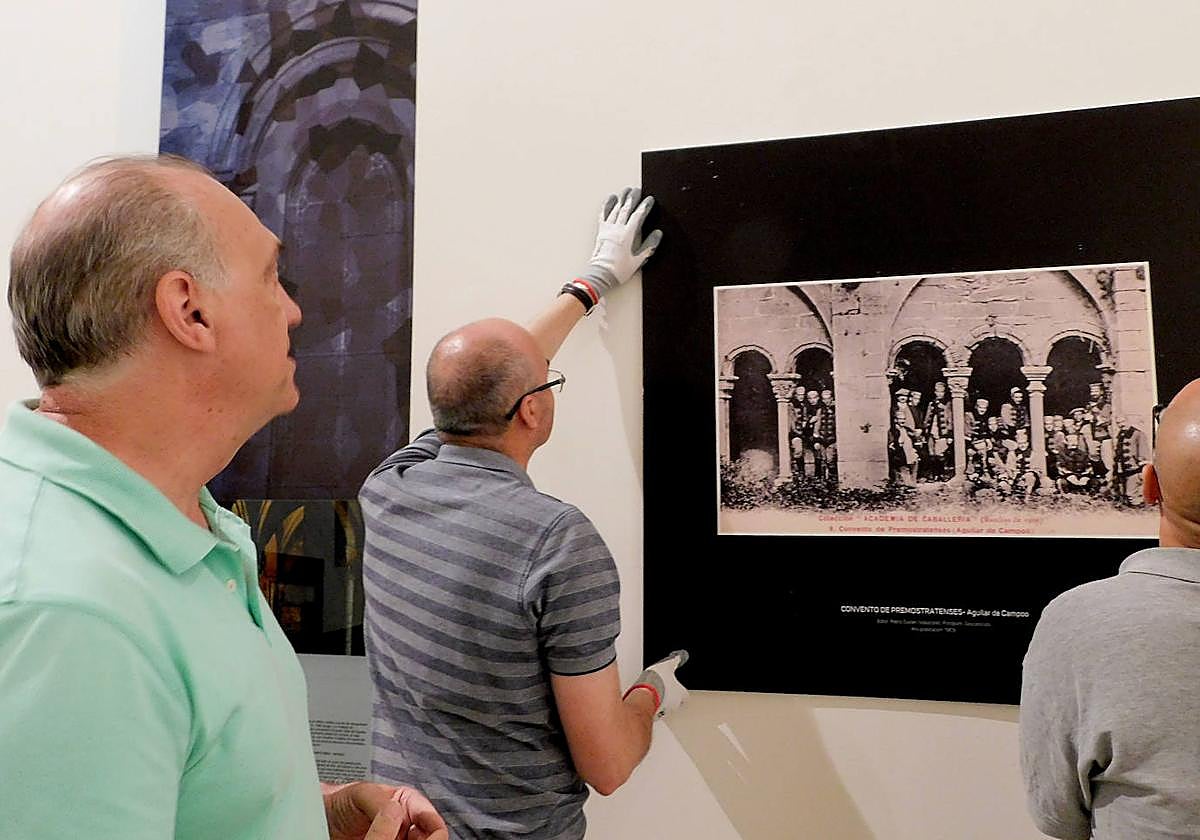 Los trabajadores colocan una de las imágenes postales en la exposición.