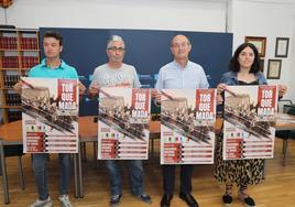 Los responsables del desarrollo de los encierros taurinos de Torquemada posan con el cartel de las fiestas.