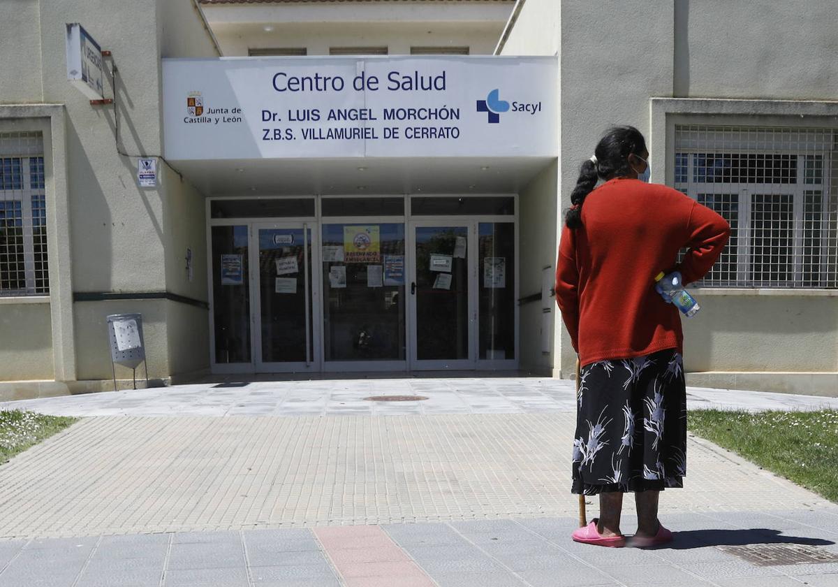 Una mujer espera en la puerta del centro de salud de Villamuriel.