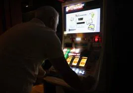 Un hombre juega en una máquina tragaperras.