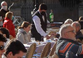 Un camarero atiende las mesas de una terraza de un restaurante en la Plaza Mayor de Segovia.