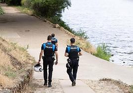 Tres agentes municipales caminan junto al río Pisuerga.