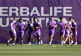 Algunos jugadores del Real Valladolid calientan en la sesión de este lunes.