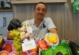 Óliver Porro muestra algunas variedades de fruta en el Mercado del Val en Valladolid.