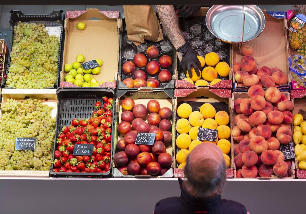 Un hombre hace la compra en una frutería de Valladolid