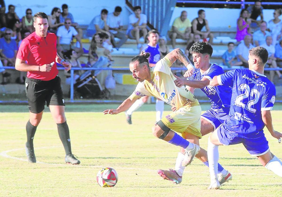 Valentín se lleva el balón ante la defensa de Moha y García en la final del Trofeo Diputación disputada este sábado en Becerril.