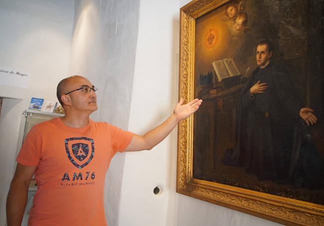 Alberto Sandoval, en la casa natal del Padre Hoyos, frente a un cuadro en el que aparece representado