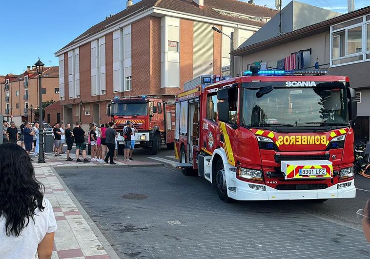 Bomberos y vecinos en la puerta del bar de Santovenia.