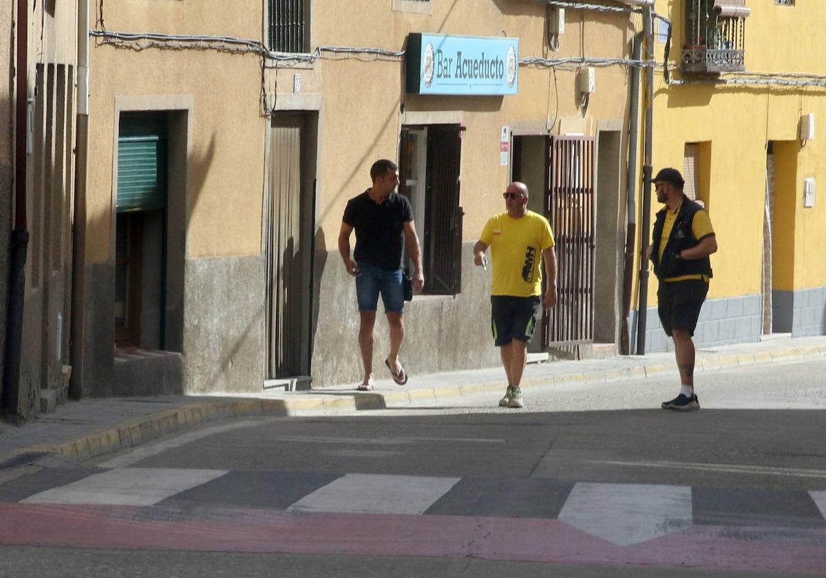 Tres hombres pasean por una de las calles de la localidad de Bernuy de Porreros.