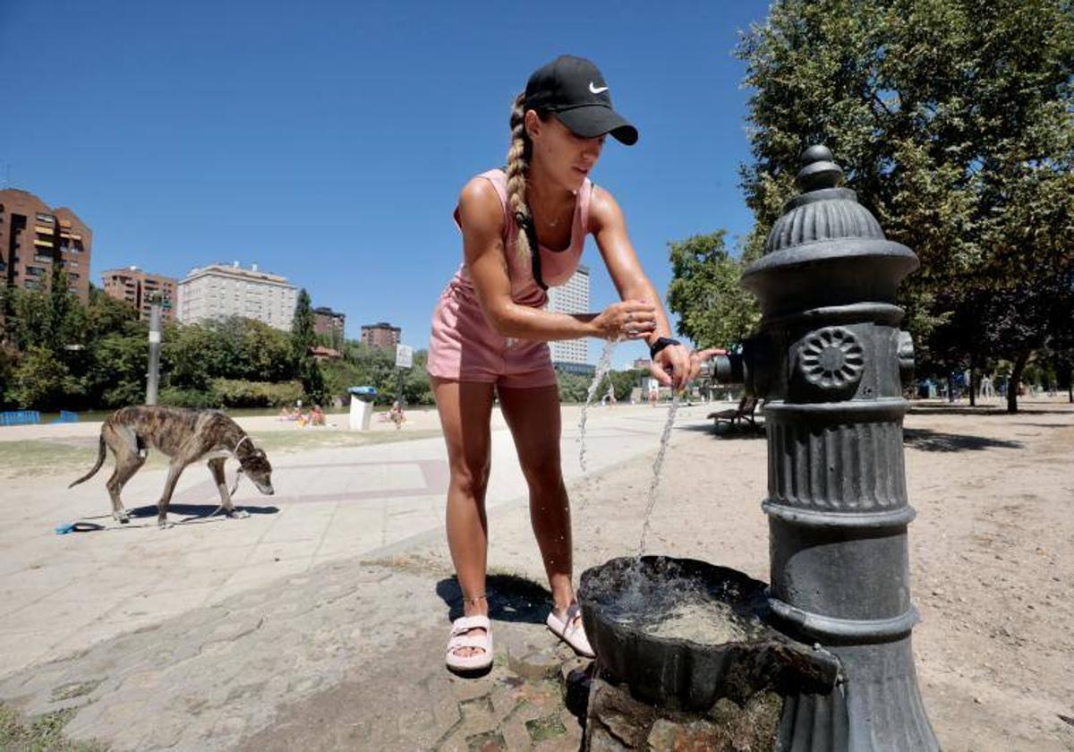 Una mujer se refresca en una fuente de la playa de Las Moreras en Valladolid.