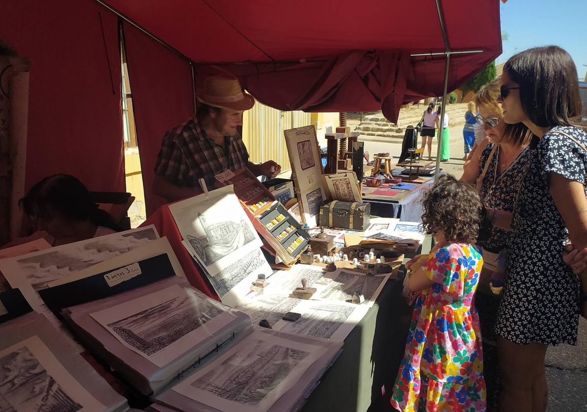 Visitantes en uno de los puestos del mercado artesanal, este sábado.