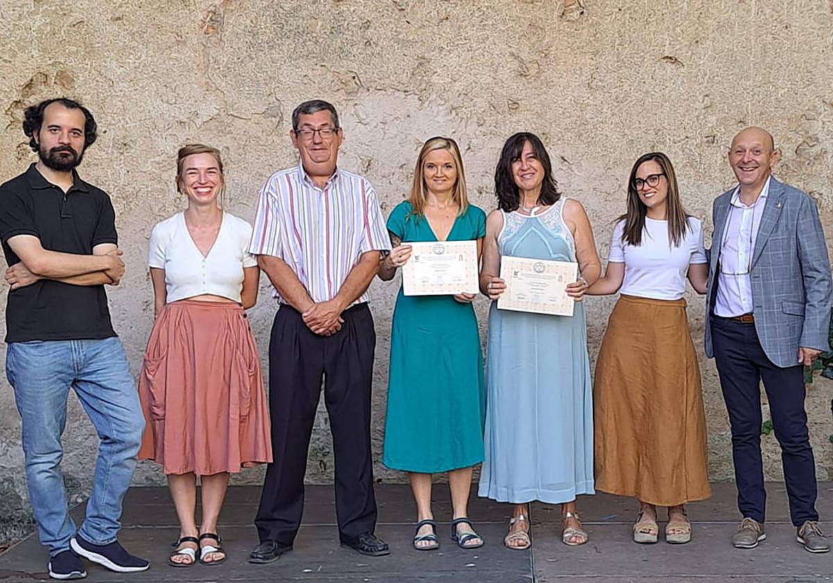 Parte del jurado y de la organización del premio literario arropan a las ganadoras, que sujetan los diplomas acreditativos.