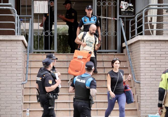 Varios vecinos abandonan el inmueble tras recoger sus pertenencias.