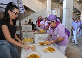 Una palentina de la peña Despenaos coge su ración de paella.