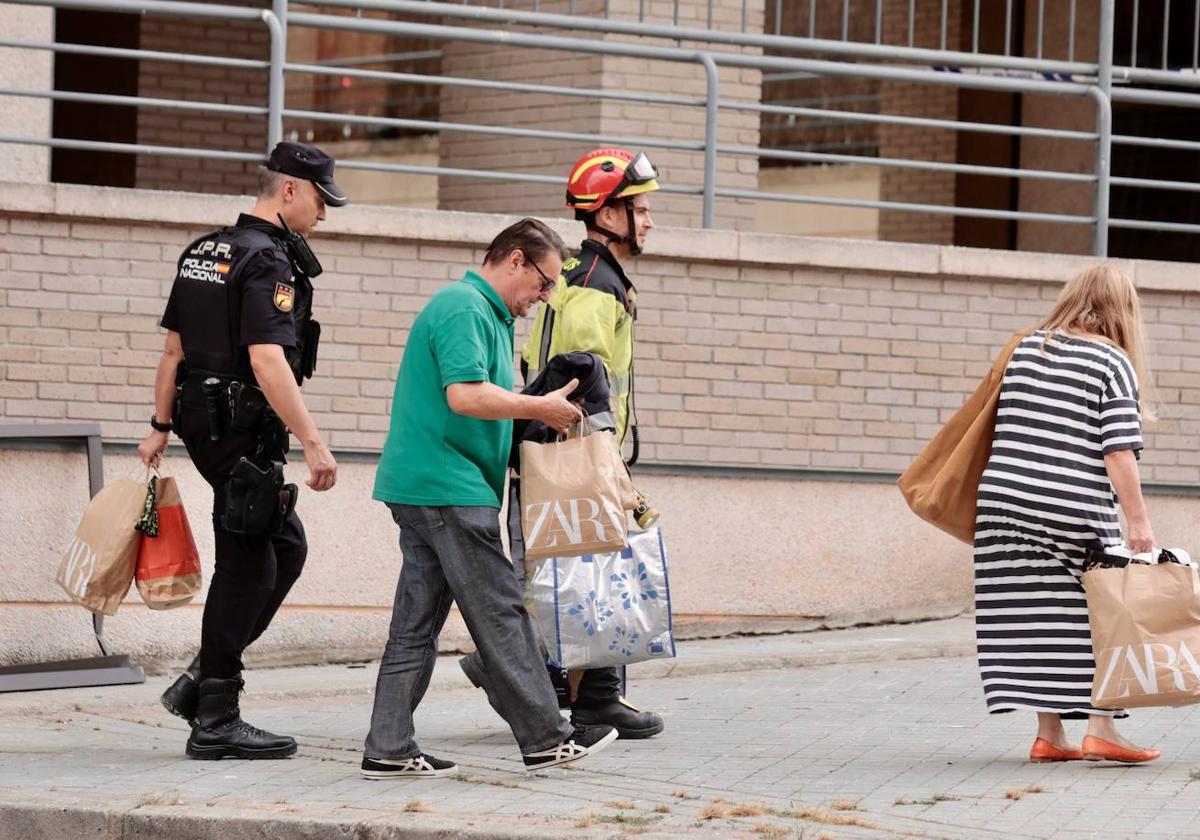 Unos vecinos del bloque recogen sus pertenencias esenciales de su vivienda esta tarde.