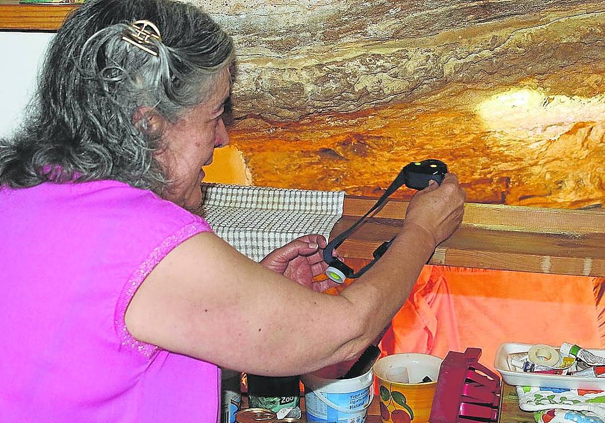 Una vecina de la ciudad enseña una de las fisuras de la roca por las que se filtra el agua a su vivienda.
