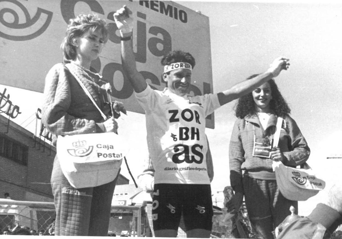 Álvaro Pino celebra radiante su maillot de líder, escoltado por dos azafatas de Caja Postal, patrocinador muchos años de la Vuelta a España.