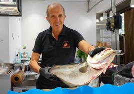 Eutiquio Arenal muestra un pescado abadejo en su pescadería.