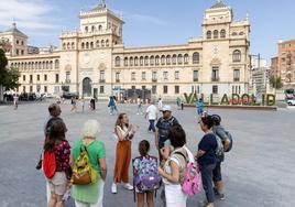 Un grupo de turistas atiende las explicaciones de una guía turística en Valladolid.